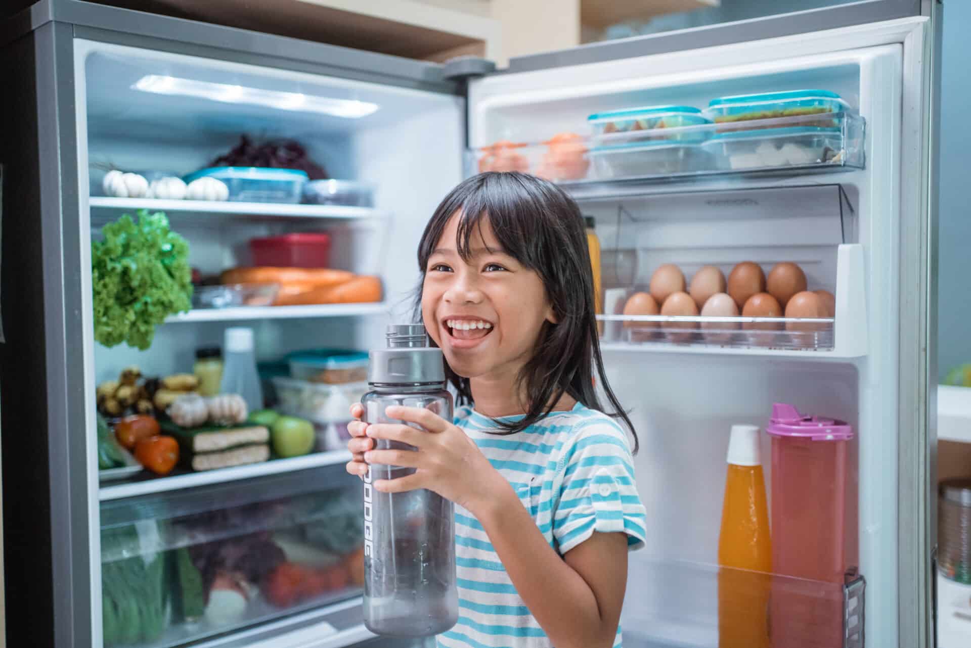 Appliance Products - asian girl open fridge door drinking a bottle of water