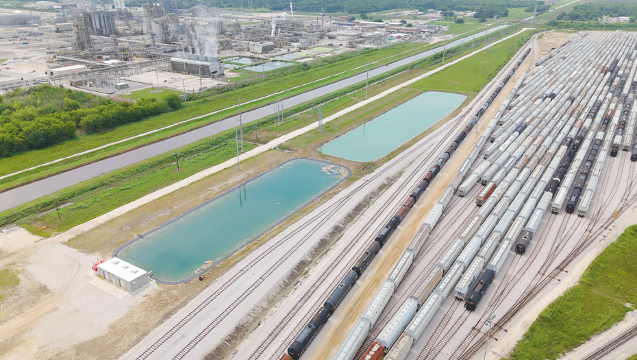 Aerial view of rail tank cars, retention ponds, and industrial infrastructure near the Beaumont plant.