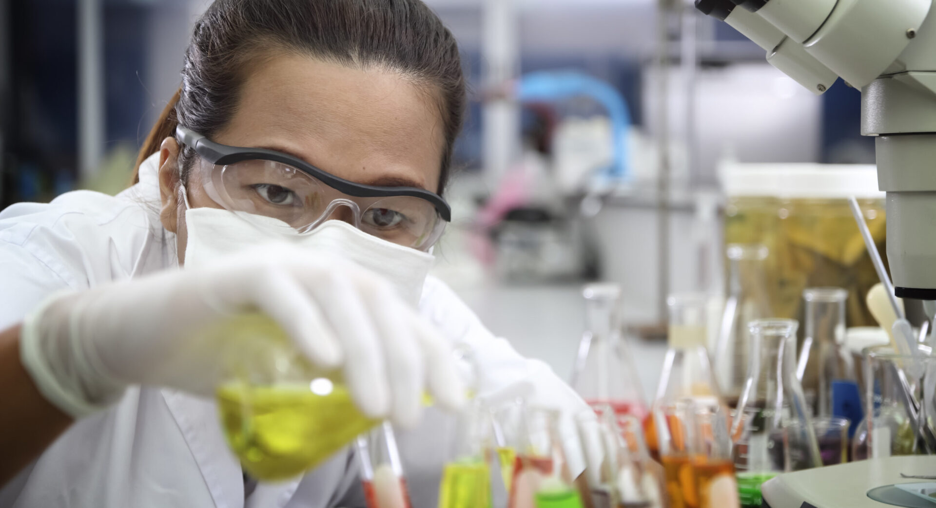 Chemist holding sample of liquid in laboratory