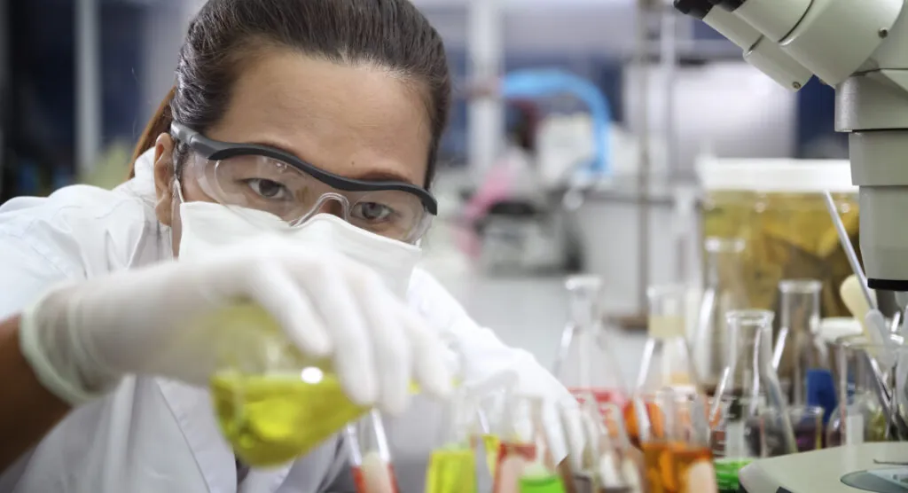 Chemist holding sample of liquid in laboratory